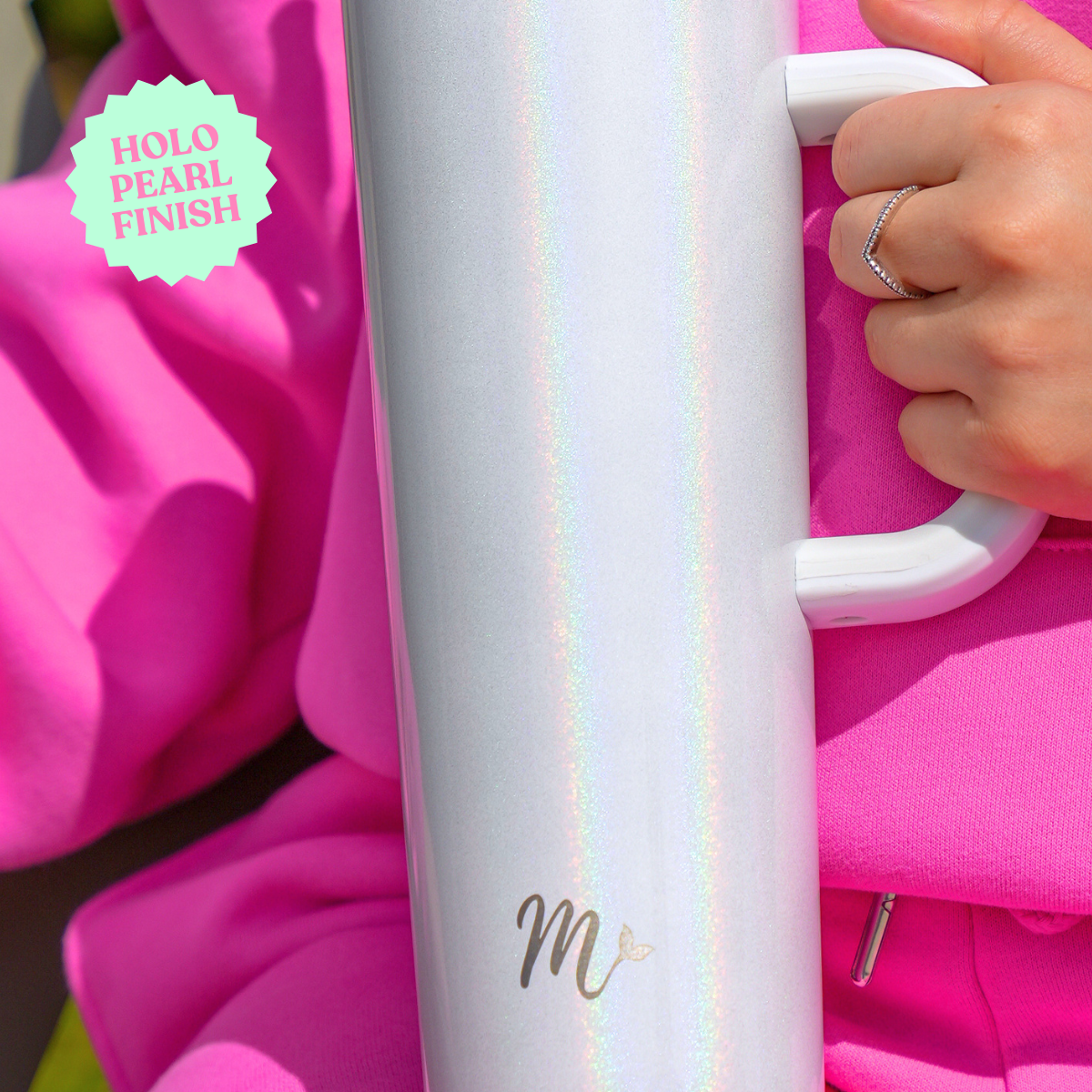 Close-up of the 30 oz Pearl Tumbler with Holo Pearl Finish - Featuring an iridescent holographic effect, ergonomic handle, and stylish design. The tumbler is being held by a woman in a pink outfit, highlighting the elegant finish and comfort of the handle.