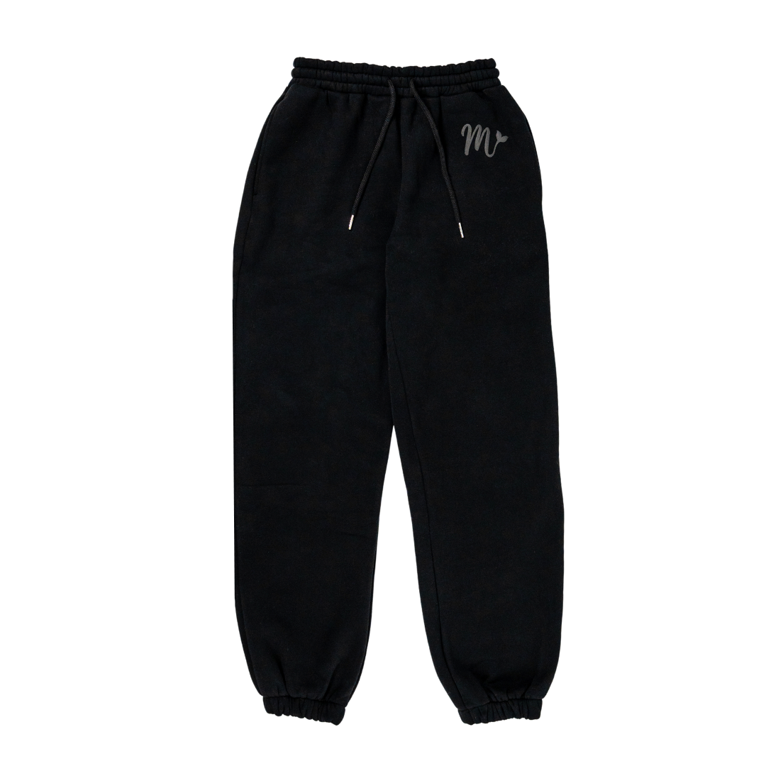 Black sweatpants with a minimalist design, featuring an elastic waistband with adjustable drawstrings and cuffed ankles. The pants have a subtle embossed logo on the left thigh, offering a stylish and comfortable fit suitable for casual wear.