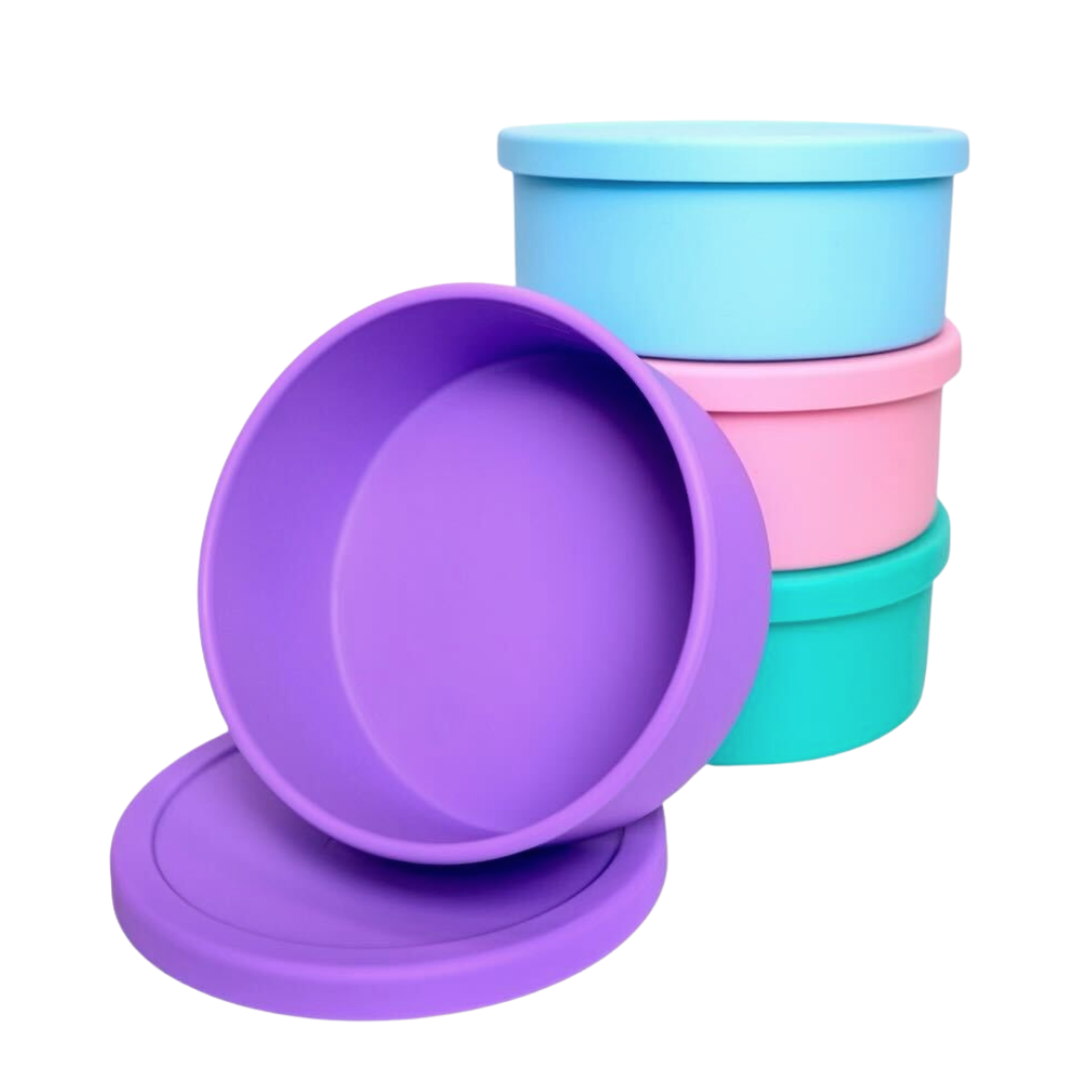 Sea foam, bubblegum, and sky blue bento bowl stacked with lid closed, and an open amethyst bento bowl leaning against other three